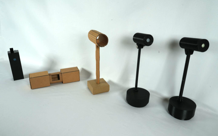 Five Beacon device iterations with cardboard and plastic prototypes